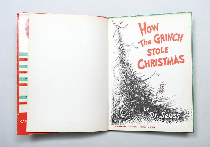 Title page from The Grinch Who Stole Christmas with the Grinch hiding behind a Christmas tree.
