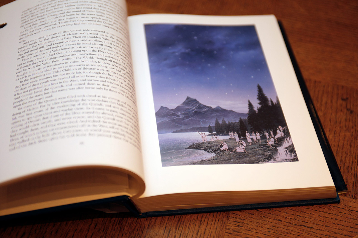 An illustration from The Silmarillion of elves seated by the shore of a lake with mountains in the distance. 